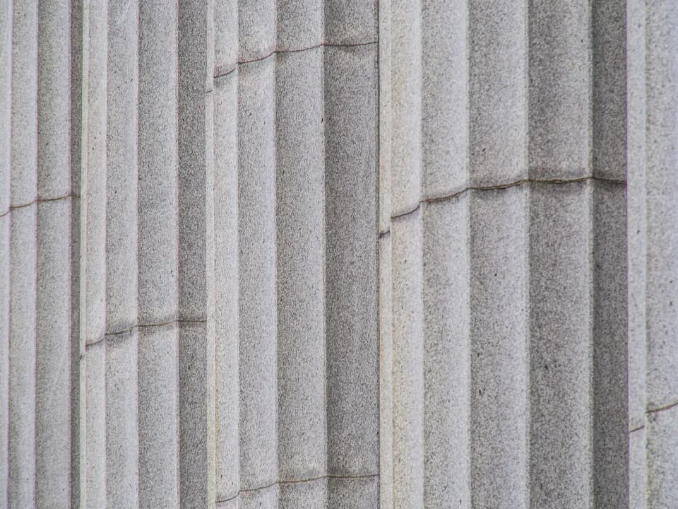 Close view of fluted neoclassical stone columns on the facade of a public building
