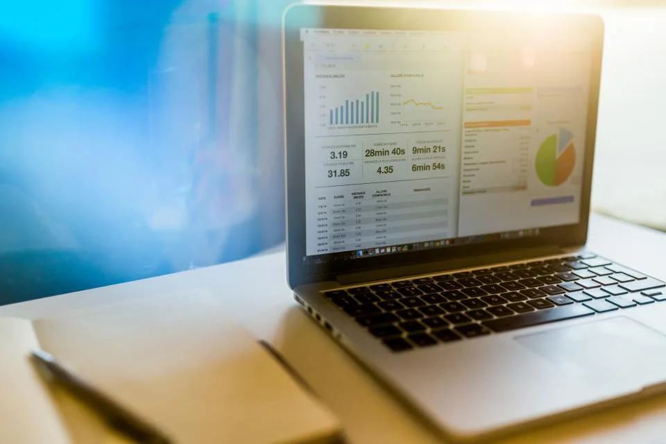 Personal injury SEO reporting dashboard on a laptop beside a notebook