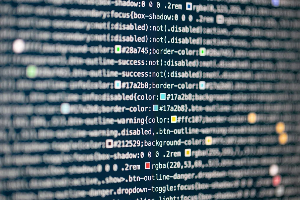 Close-up of a computer monitor showing lines of CSS source code with colored hex values highlighted